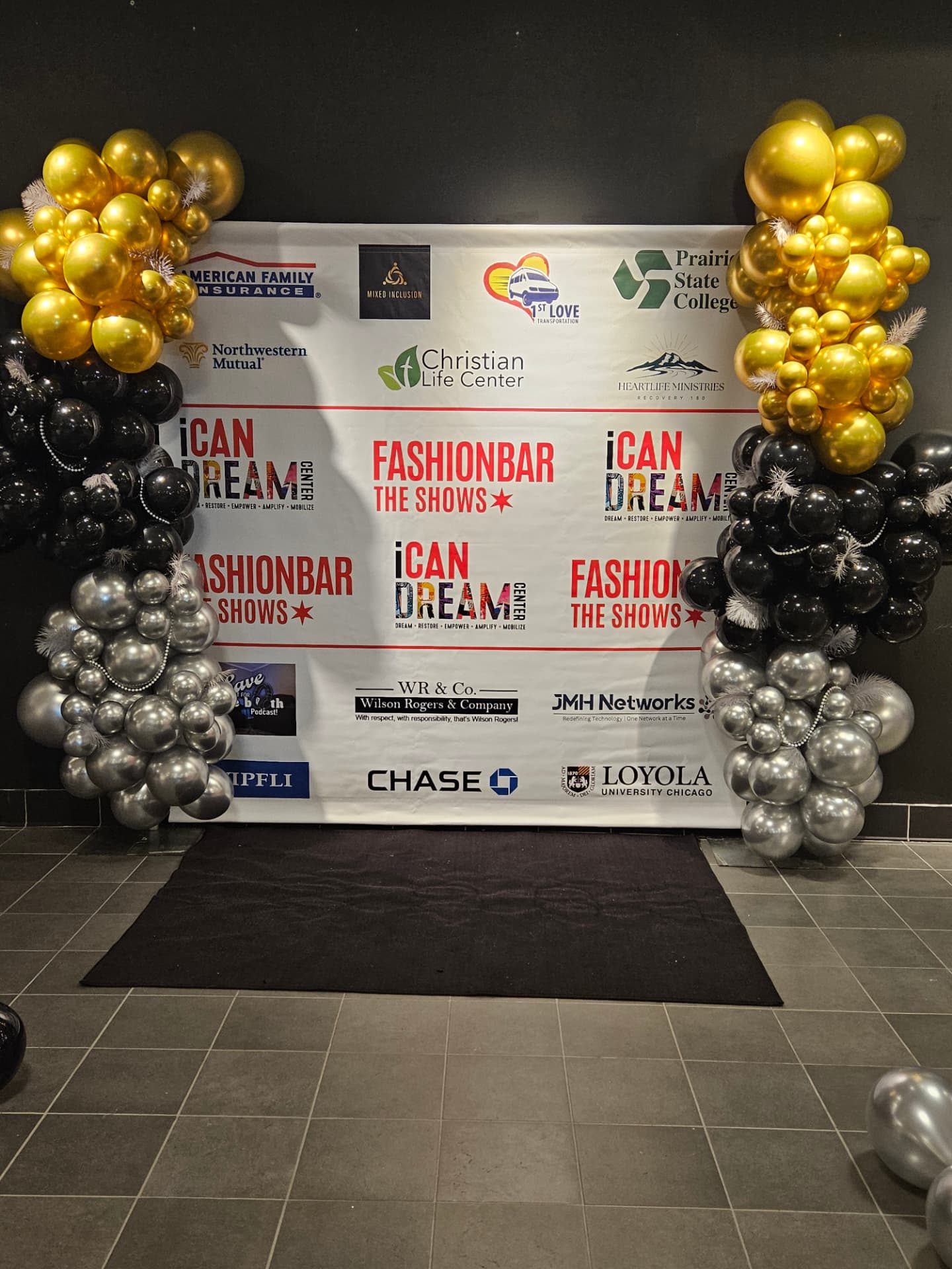 non-profit event planner Chicago - branded step-and-repeat backdrop with gold, black and silver balloon garlands